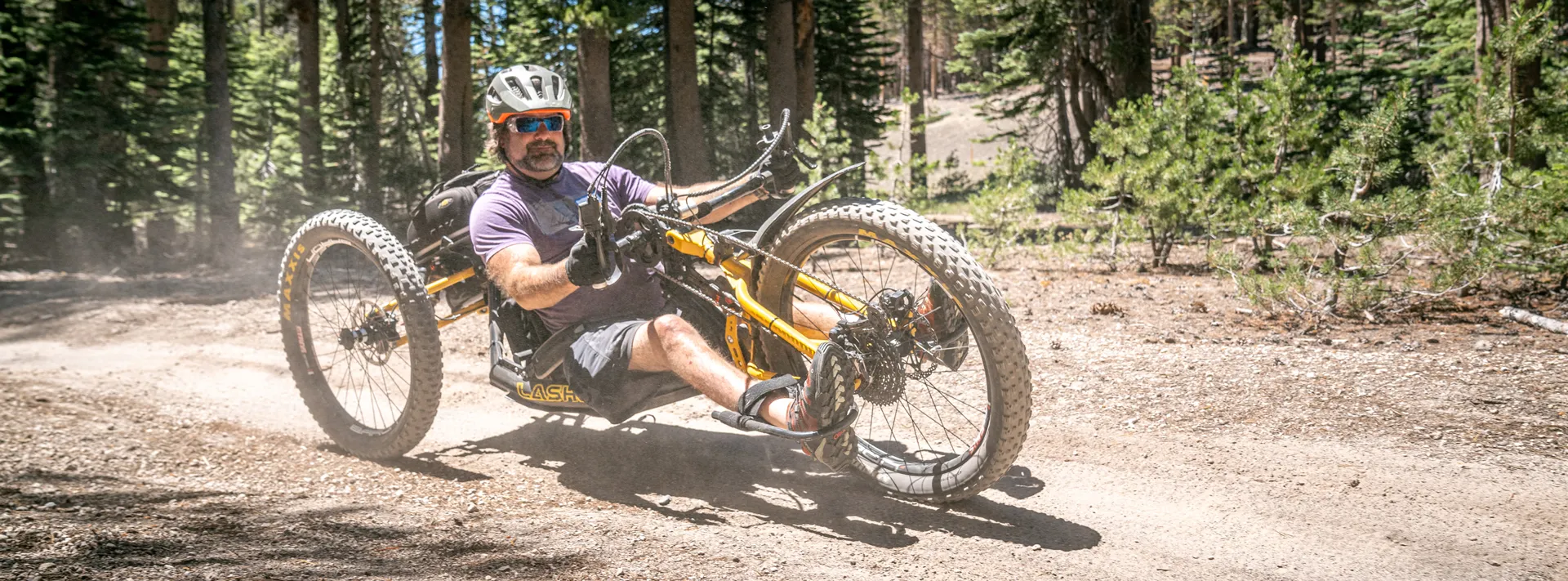 image An Access Mammoth instructor with athlete road biking down a highway smiling at the camera