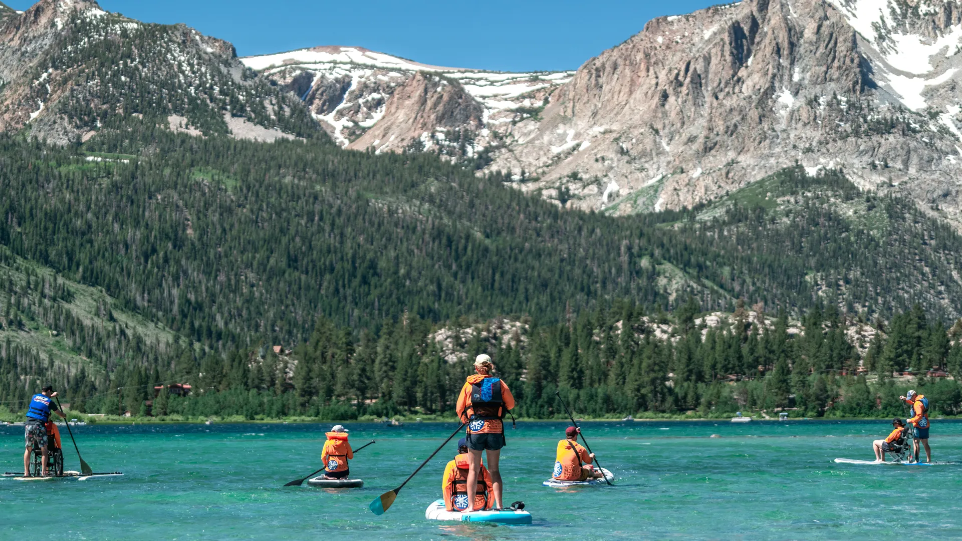 Group of Access Mammoth instructors and athletes paddle boarding during one of our summer programs