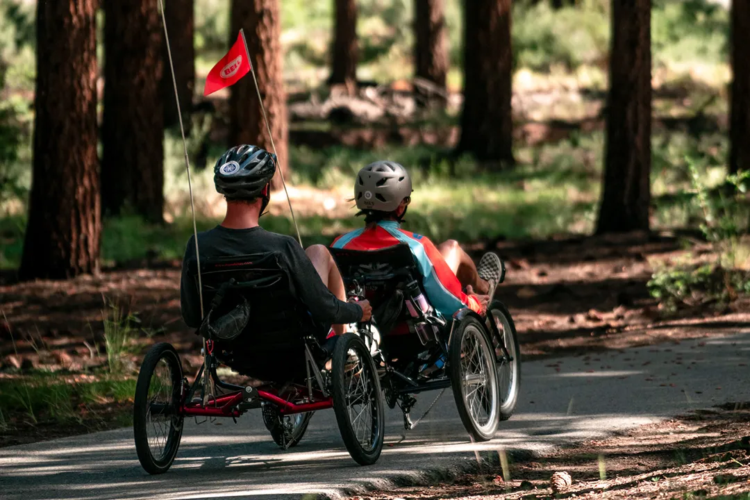 An Access Mammoth adaptive athlete and instructor riding a tandem road bike during our summer programs