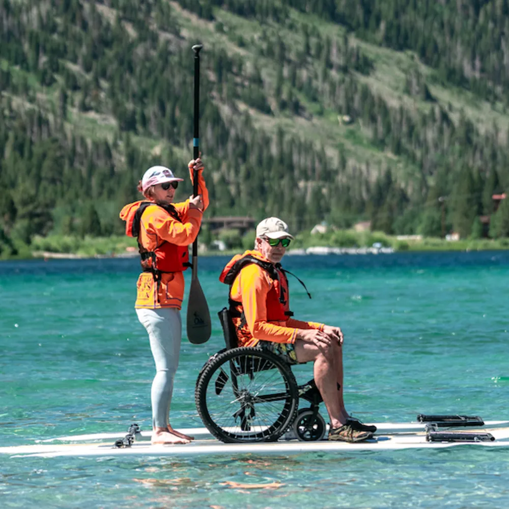 About Us page photo featuring Access Mammoth participant with an instructor on a paddle board on the lake.