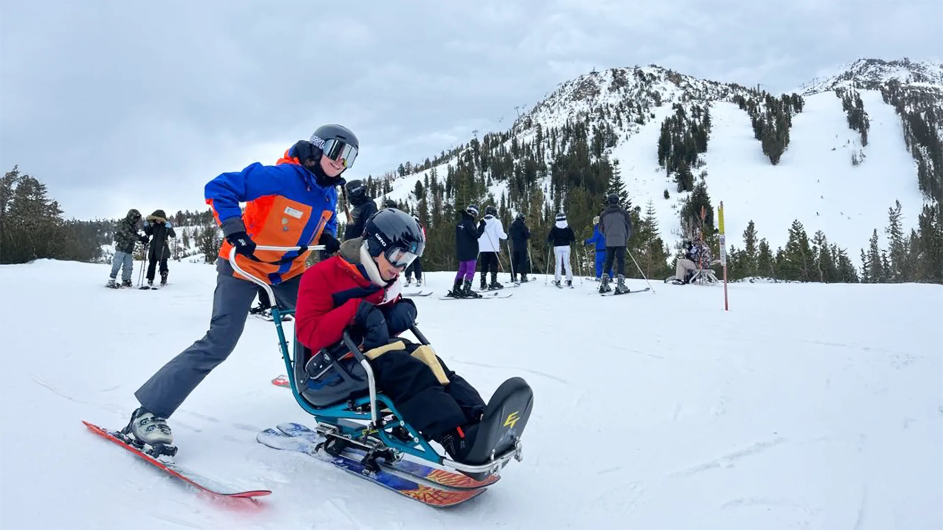 image An Access Mammoth instructor with athlete road biking down a highway smiling at the camera